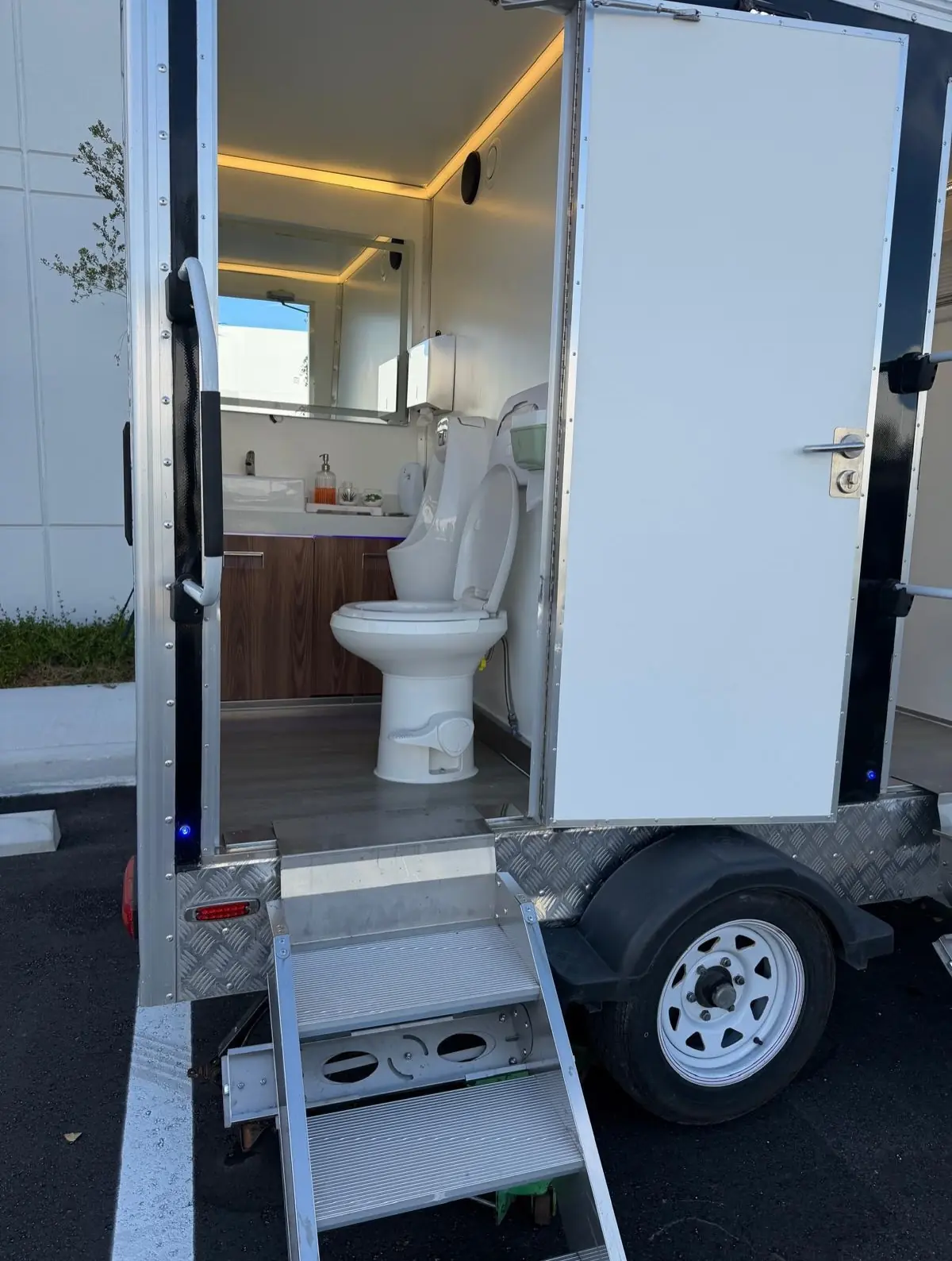 Luxury restroom trailer with wood vanity and lighting