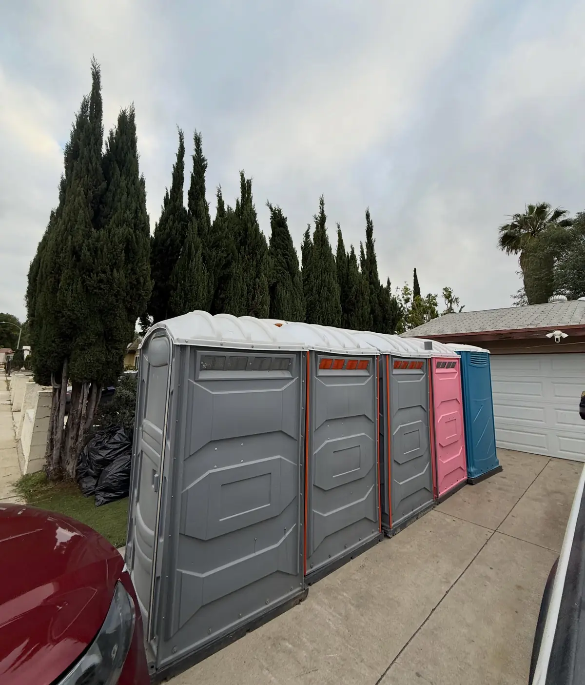 Row of porta potties along a block wall for a rental in Menifee